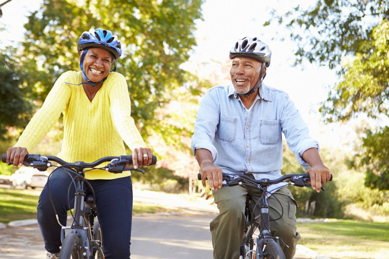 Happy couple riding bicycles wearing helmets